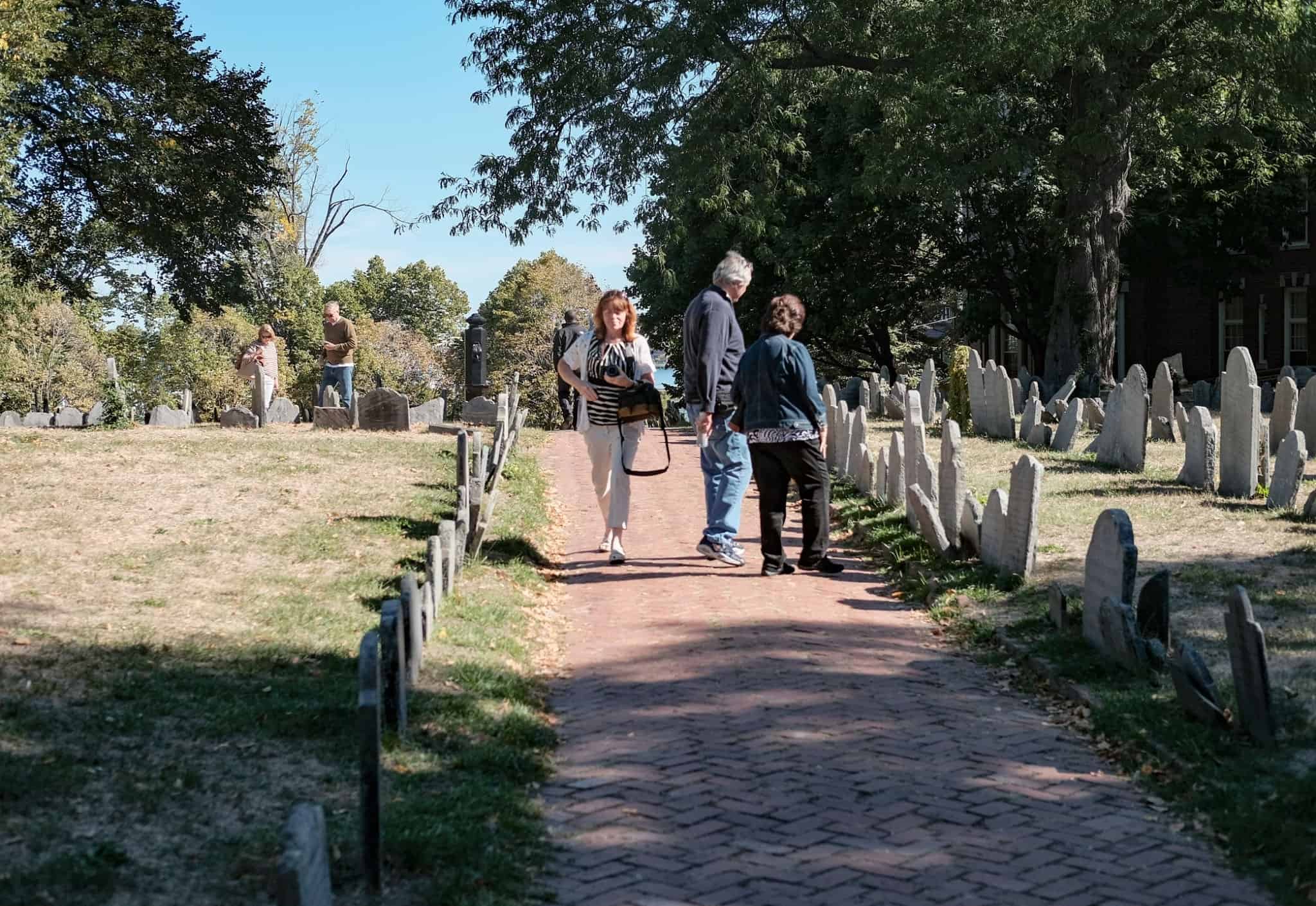 Visitors to an old graveyard in Boston, MA