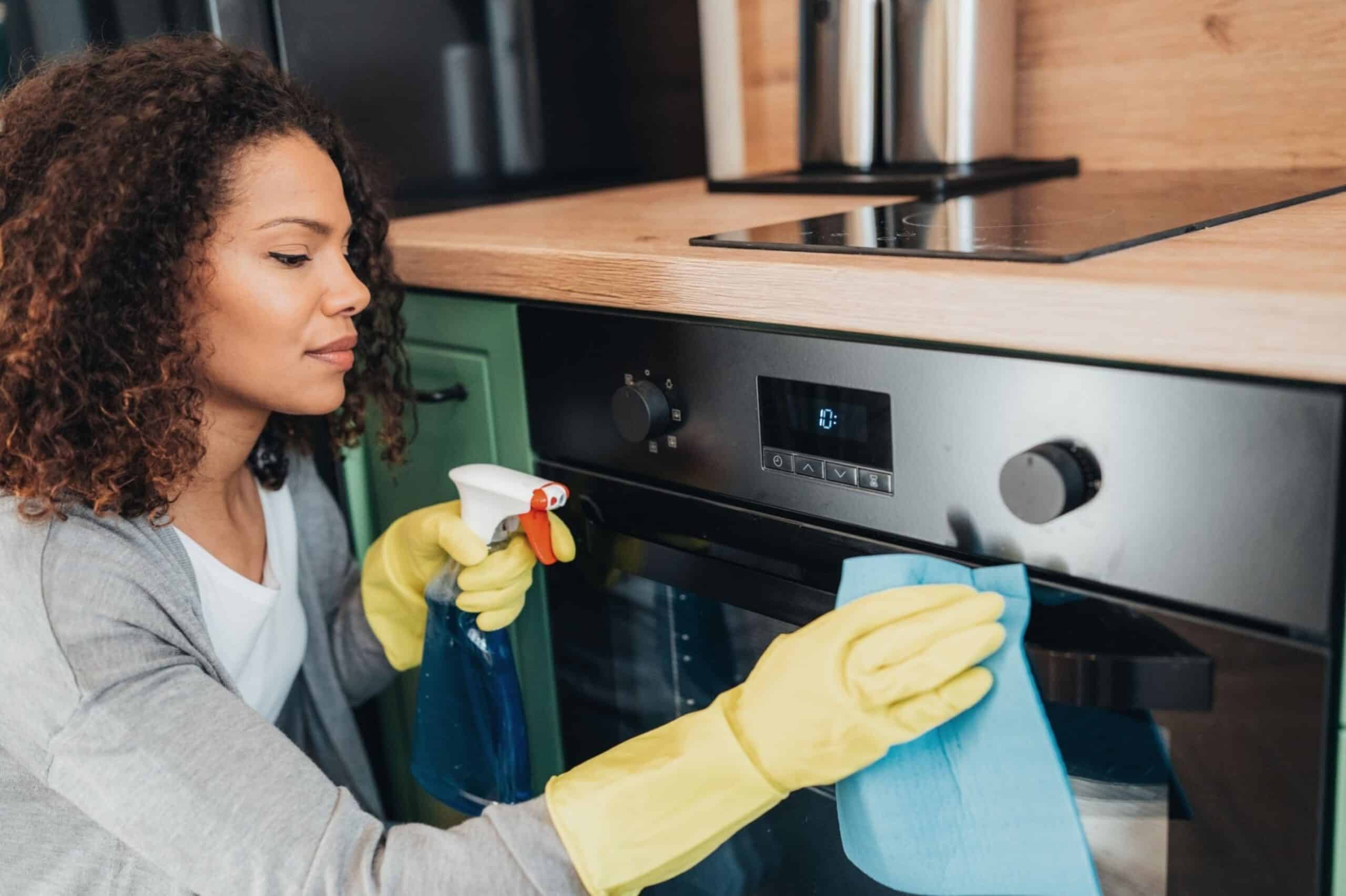 Woman cleaning with disinfectant and gloves at home