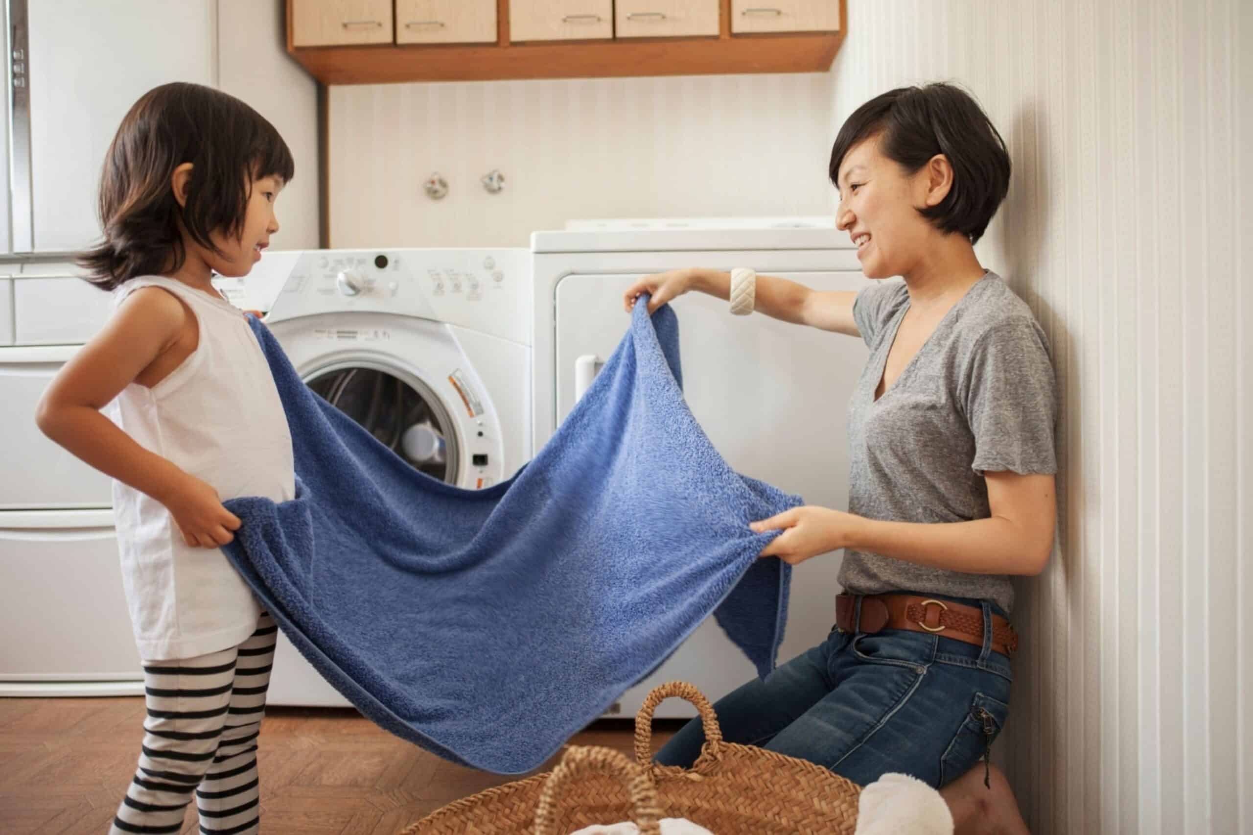 Mother and daughter folding towel