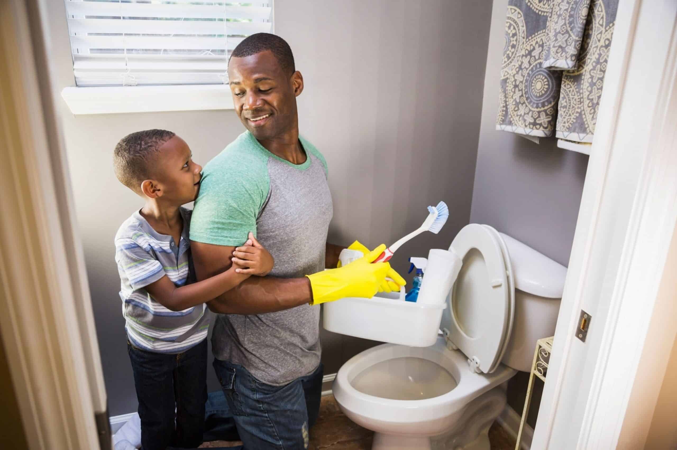 man with son cleaning bathroom toilet