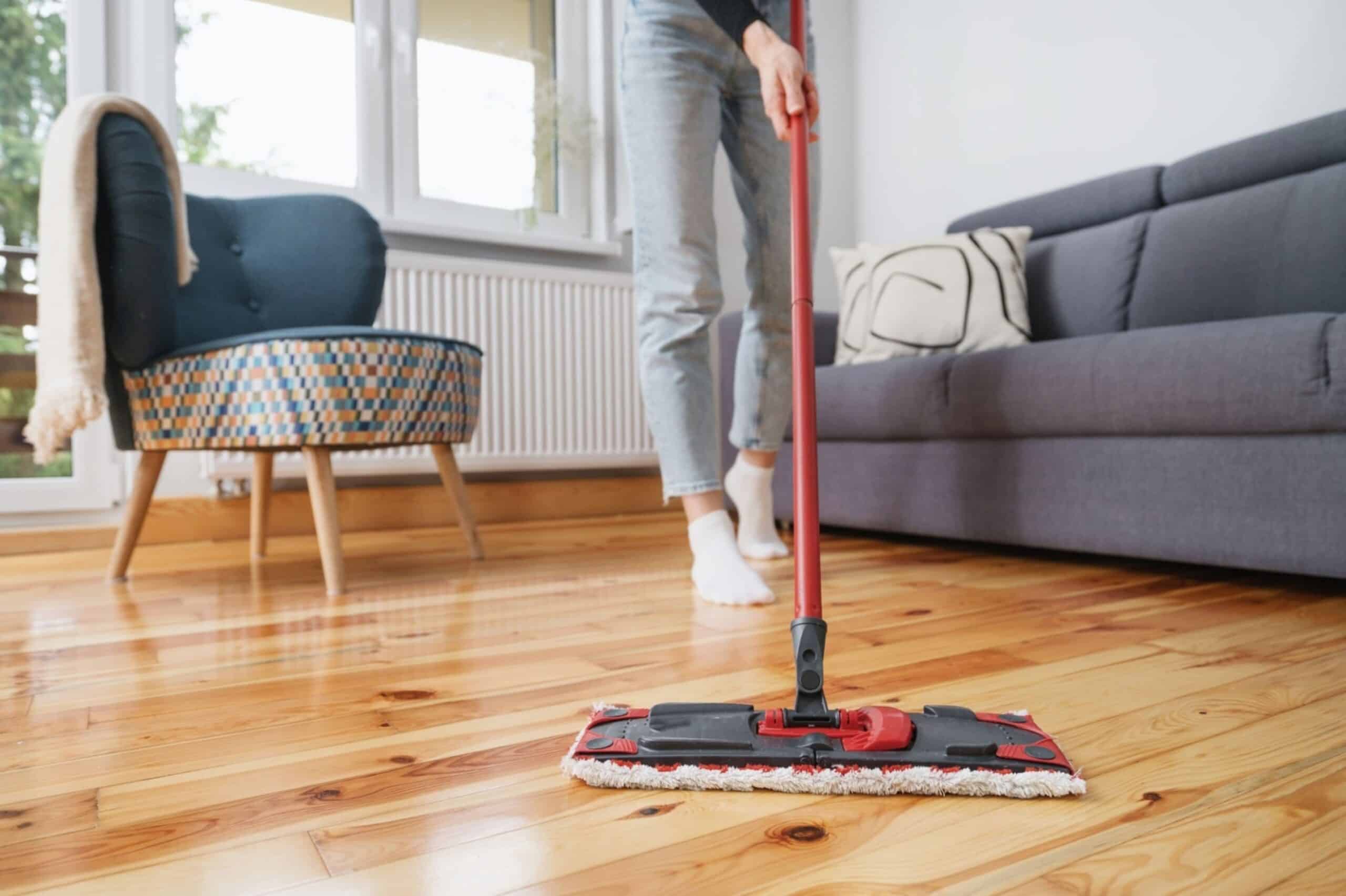 Woman cleaning wooden floor with mop