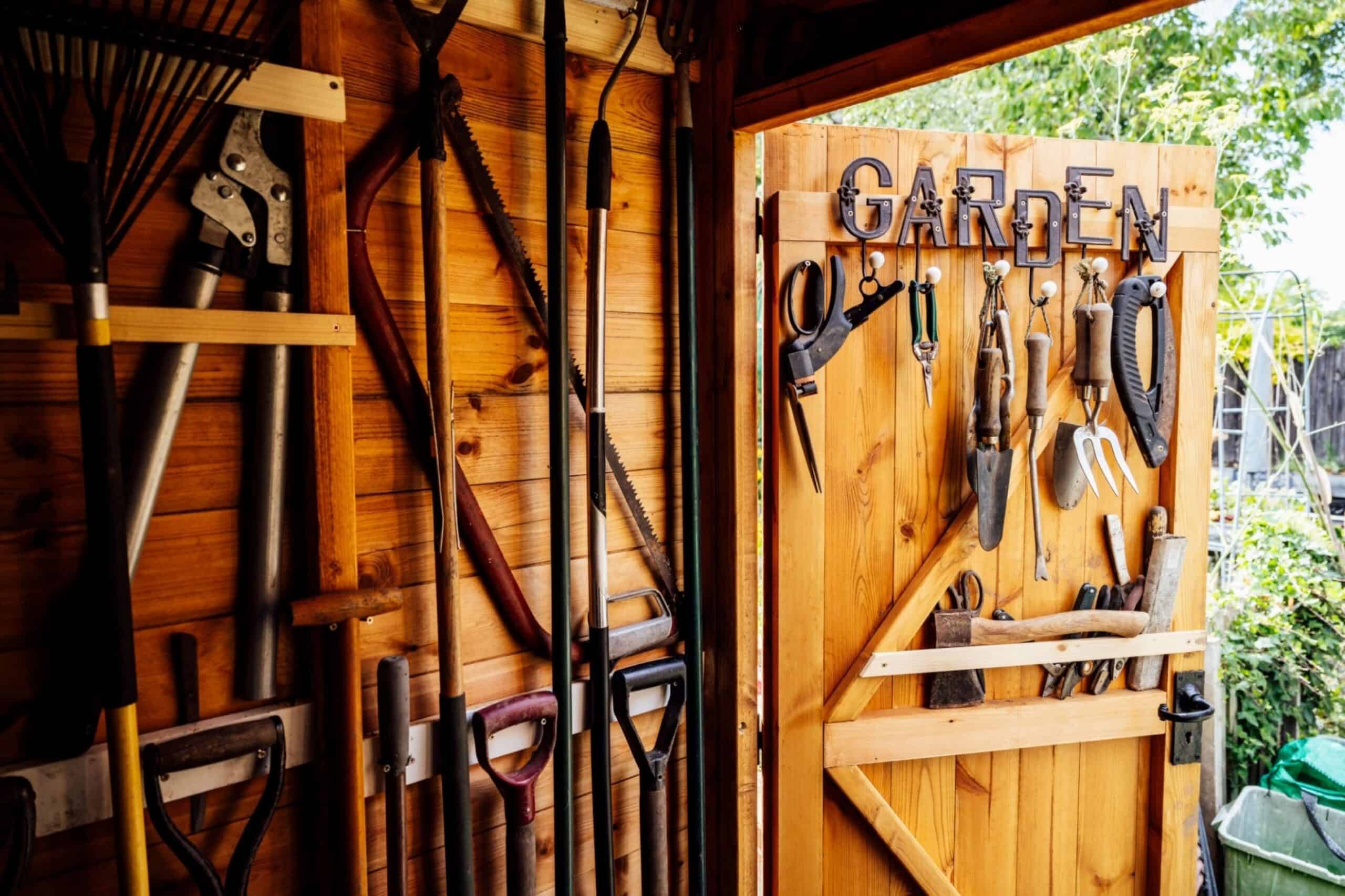 organized shed filled with rake, shovels, trimmer, saw, and other hand tools required for maintenance