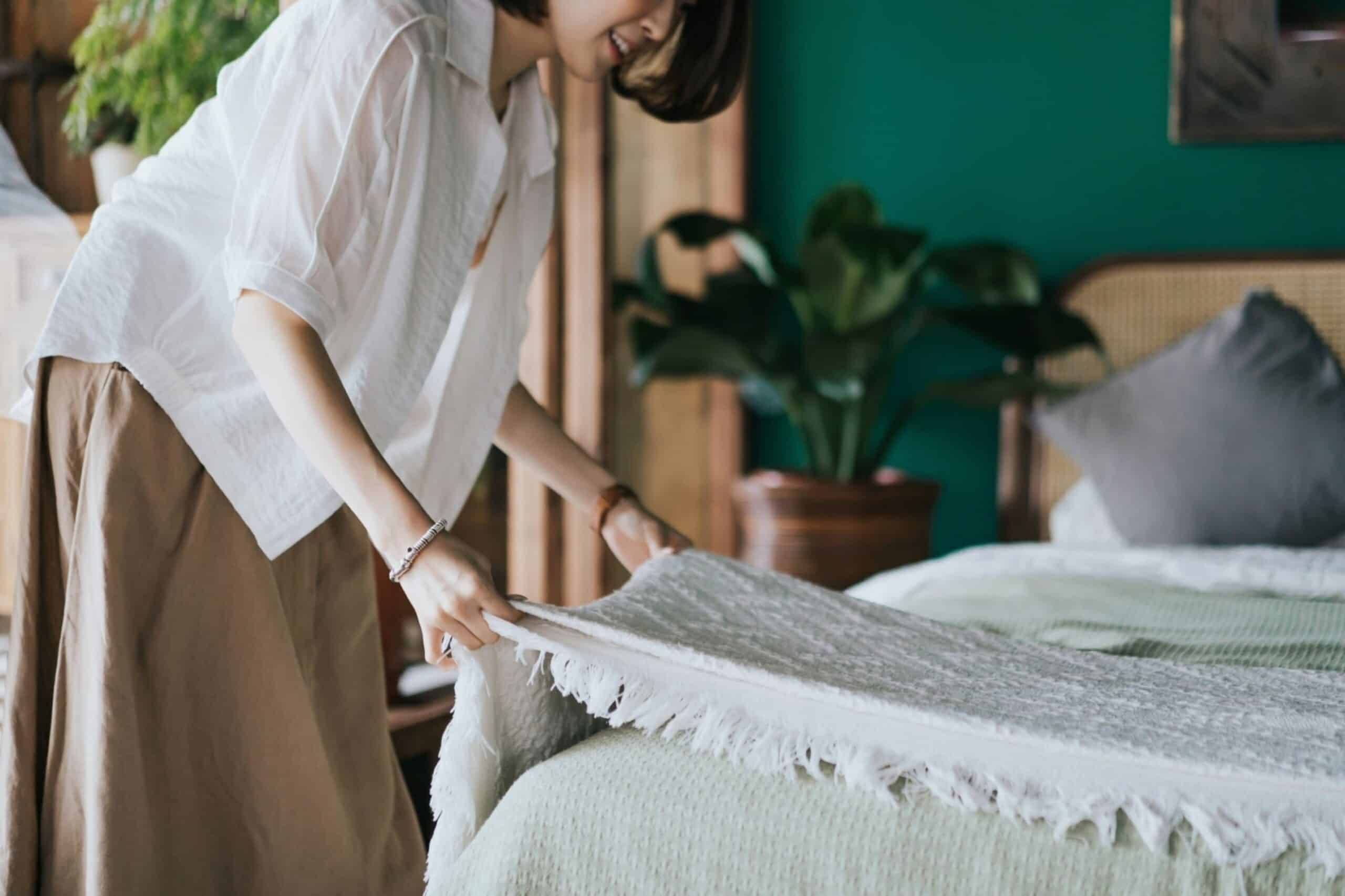 woman making up her bed at home