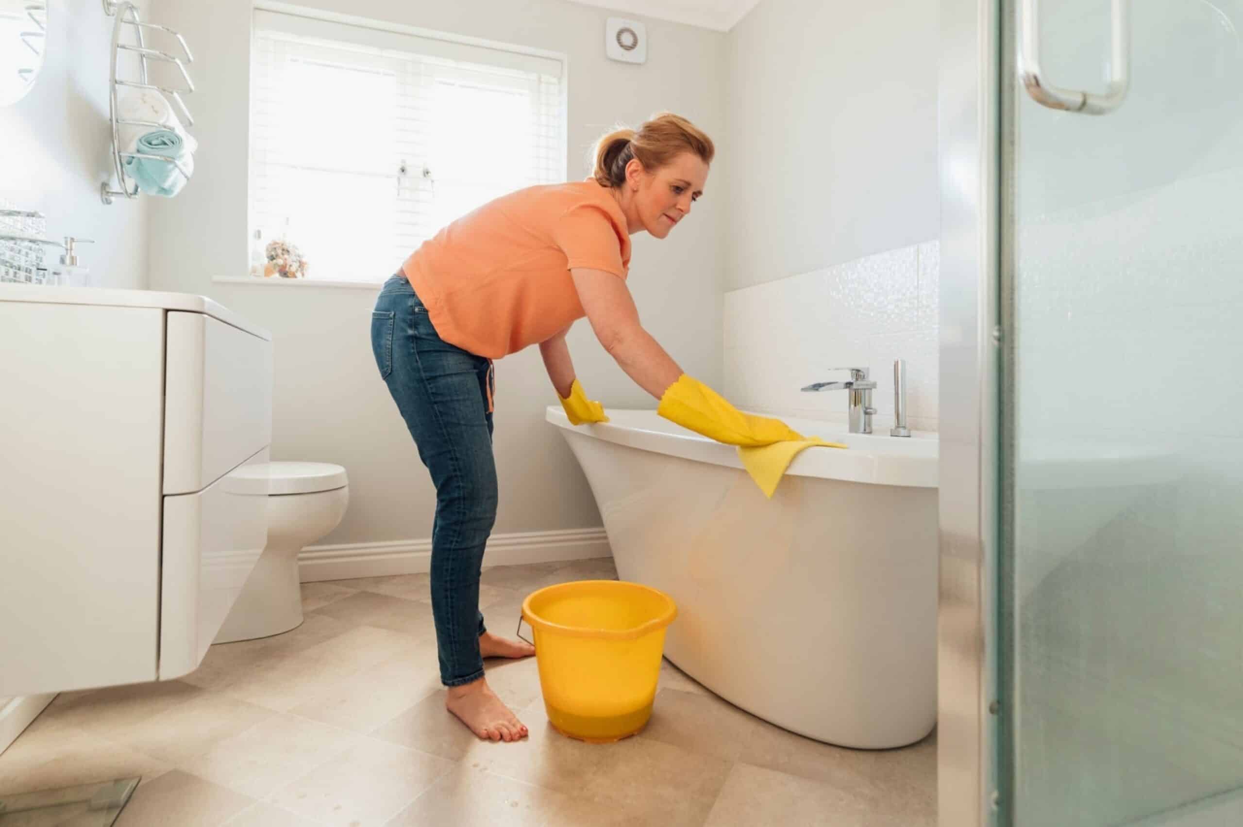 Cleaning Supplies List Image of a Woman Cleaning the Tub