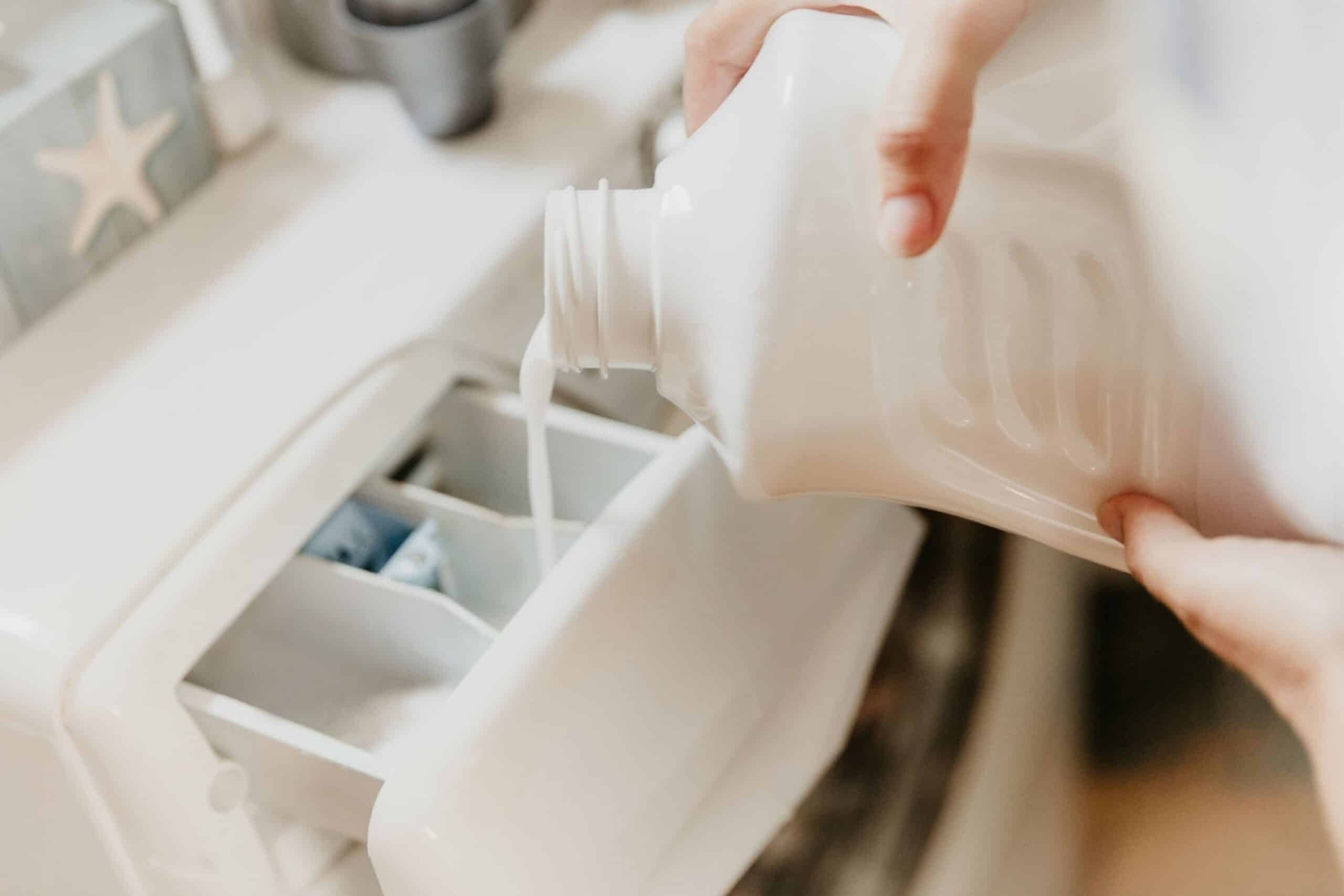 How to Clean a Washing Machine Image Pouring Washing Liquid in Washing Machine