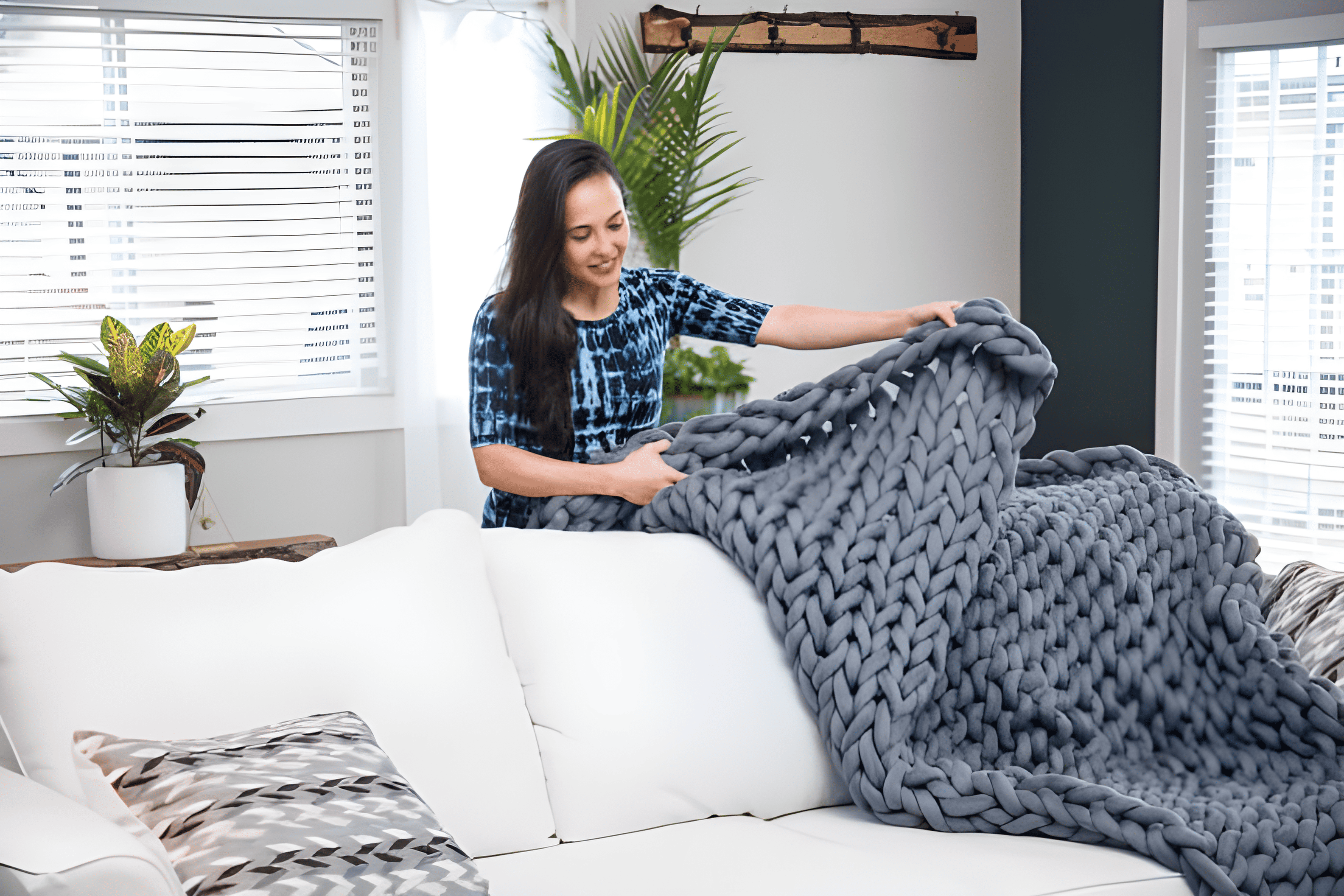 How to Wash a Weighted Blanket According to Experts Tidyhere Image of a Woman Placing Knitted Weighted Blanket on White Couch