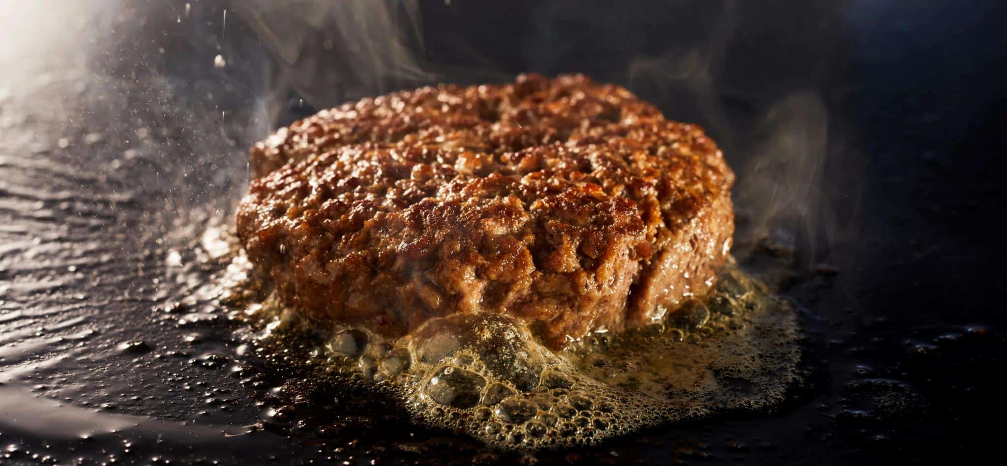 How to Clean a Blackstone Griddle Tidyhere  Image of a Thick Juicy Minced Beef Patty for a Traditional Burger Grilling on a Griddle